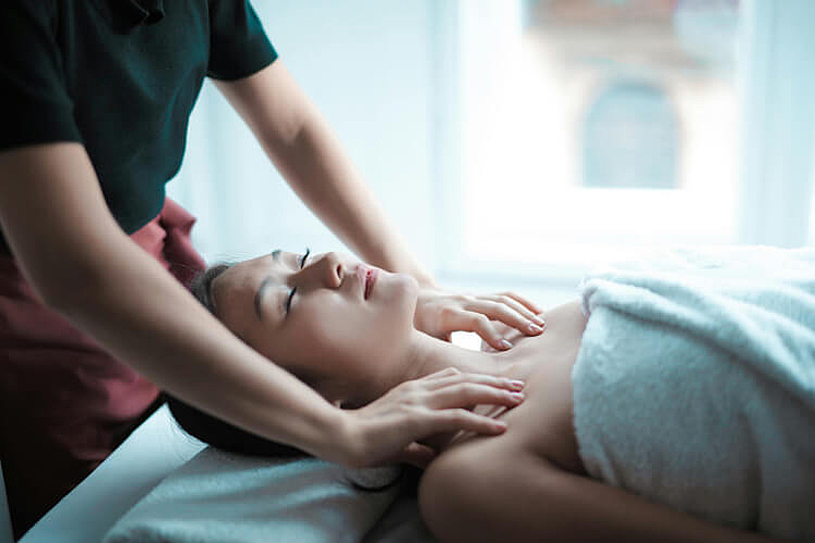 Eine Frau lässt sich in einem Massagestudio ihre Nackenverspannungen lösen.